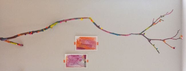 A decorated long branch is seen extended on a wall.