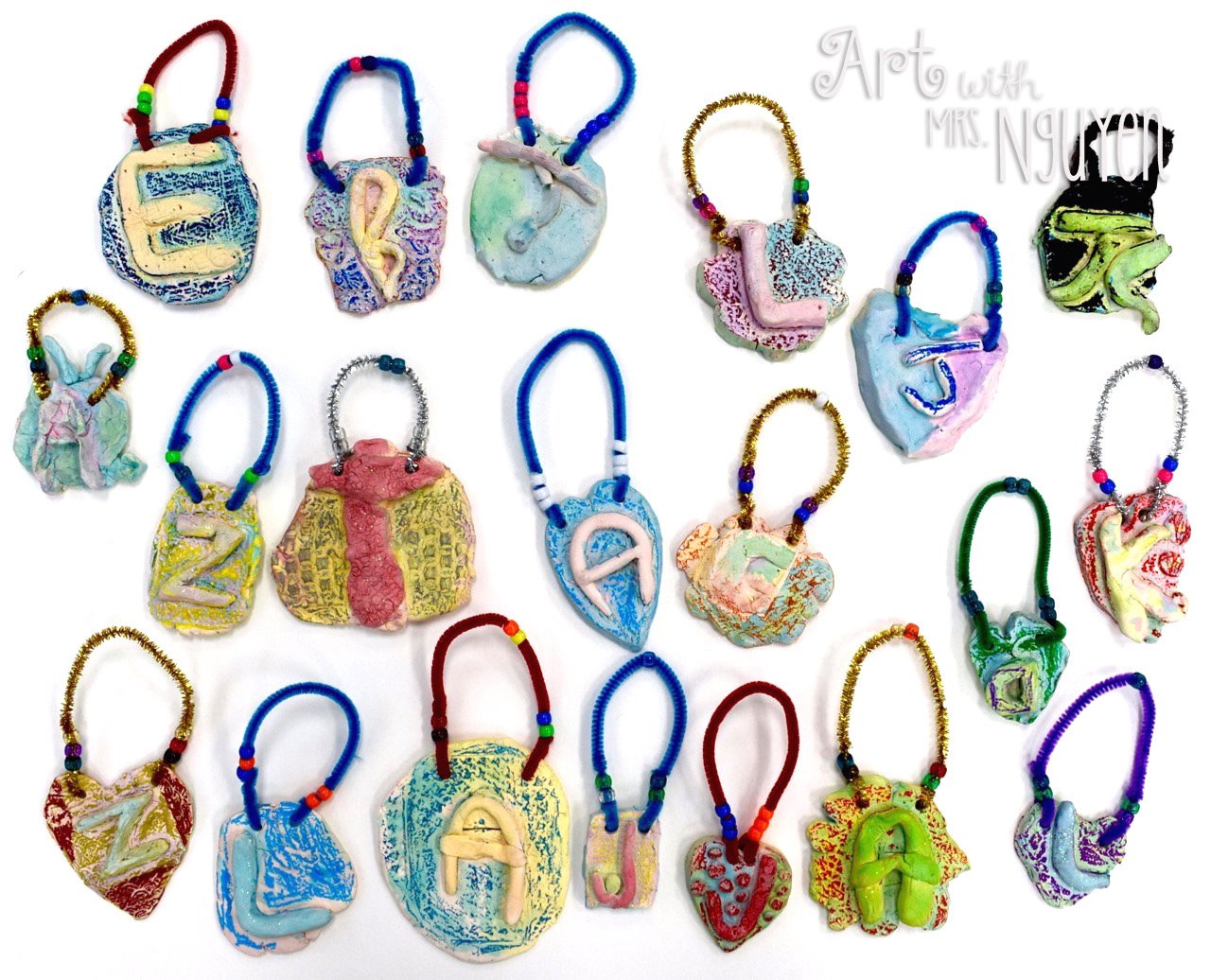 Small clay ornaments with textured backgrounds featuring individual letters