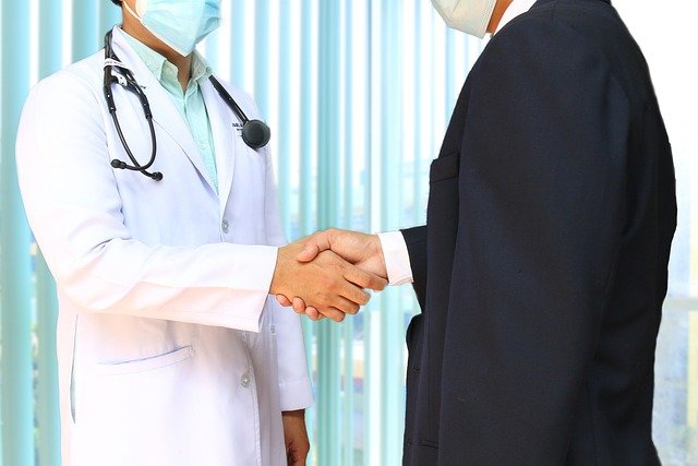 A doctor and a hospital administrator shake hands