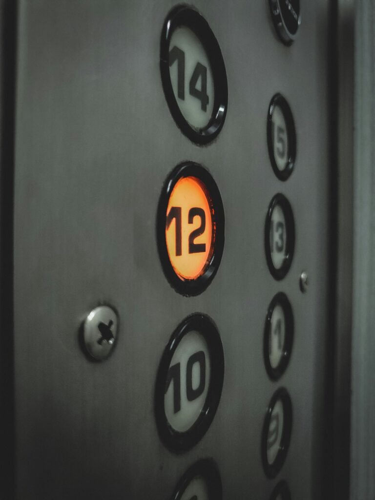 Closeup of elevator button panel, with the number 12 lit up