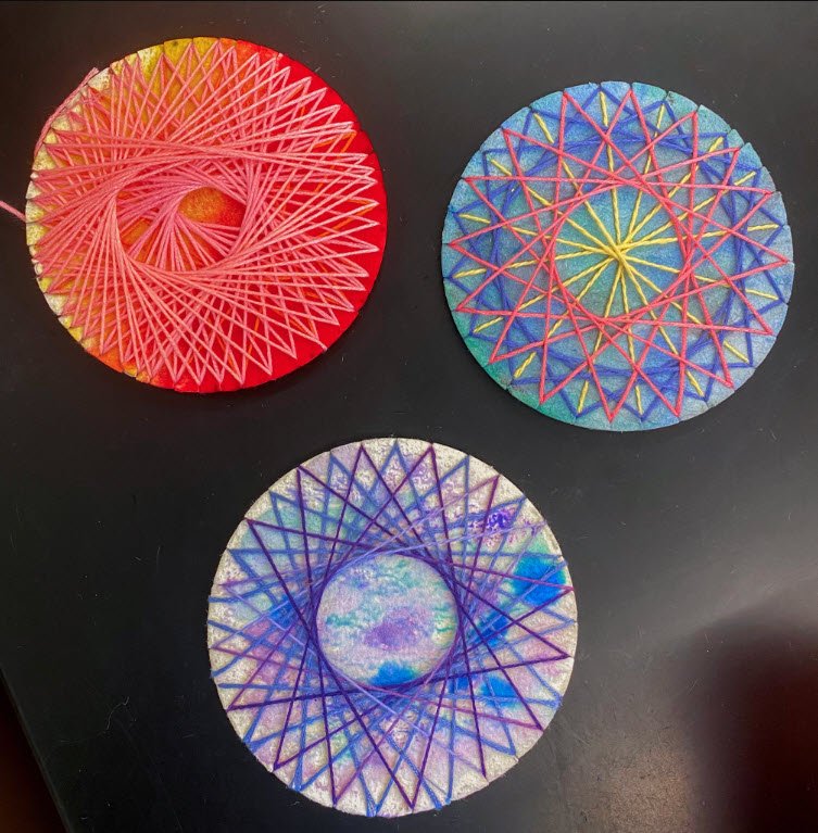 Three circular geometric string art creations made by fourth graders