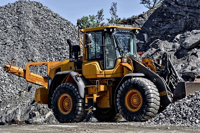 A heavy equipment operator drives a bulldozer at a mining site,