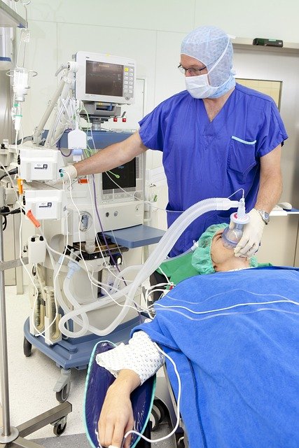 A nurse  Anesthetist monitors a patient during surgery