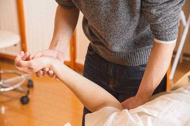 An occupational therapist works on a woman's injured arm