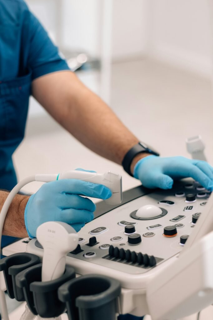 An ultrasound technician stands by sonogram equipment