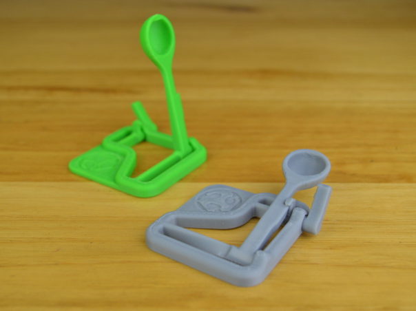 Small green and grey 3d printed catapult toys as an example of 3D printing ideas