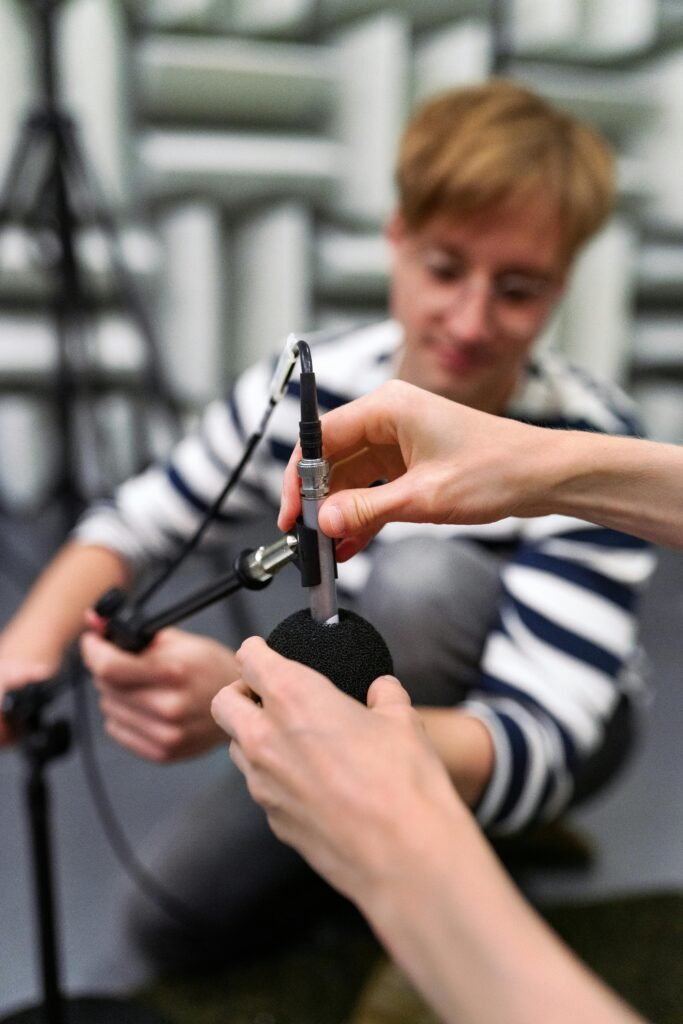 A person's hands are seen adjusting a microphone.