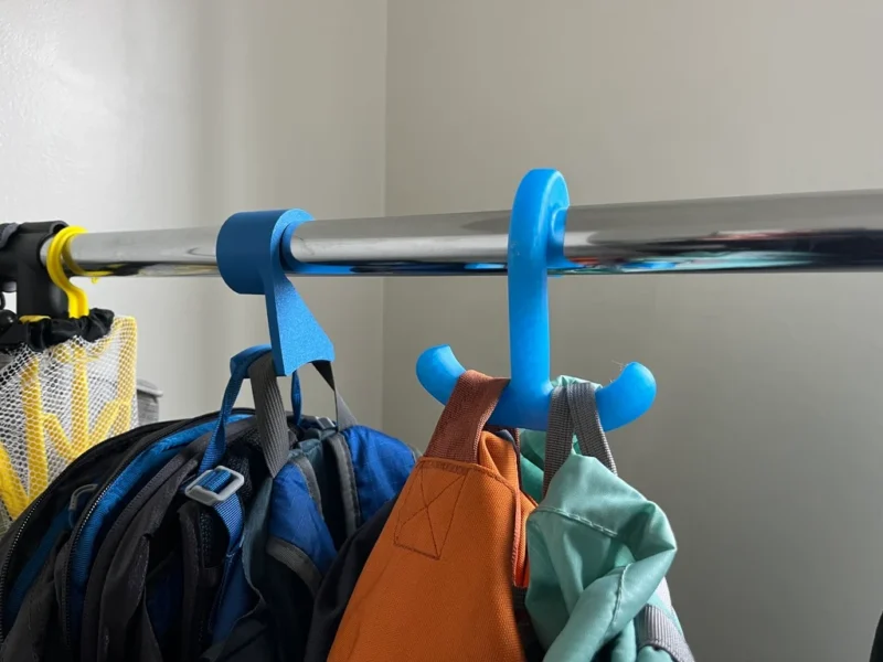 Two blue hangers are shown holding backpacks in this example of 3D printing ideas