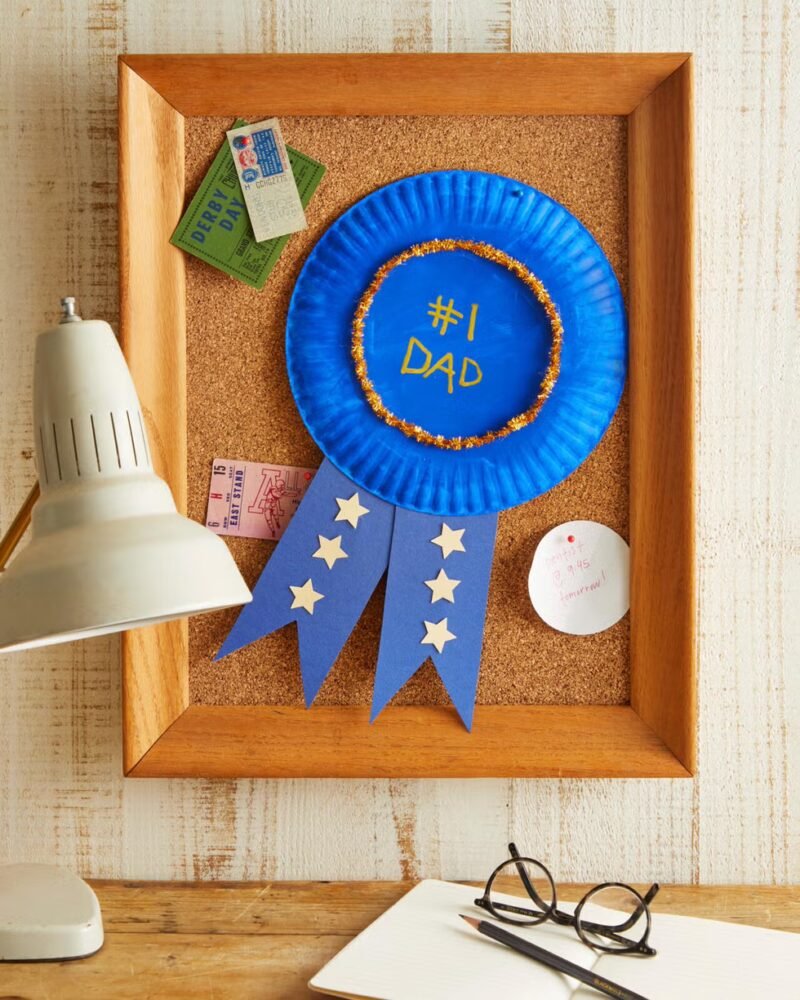 A Father's Day blue ribbon craft made from a paper plate