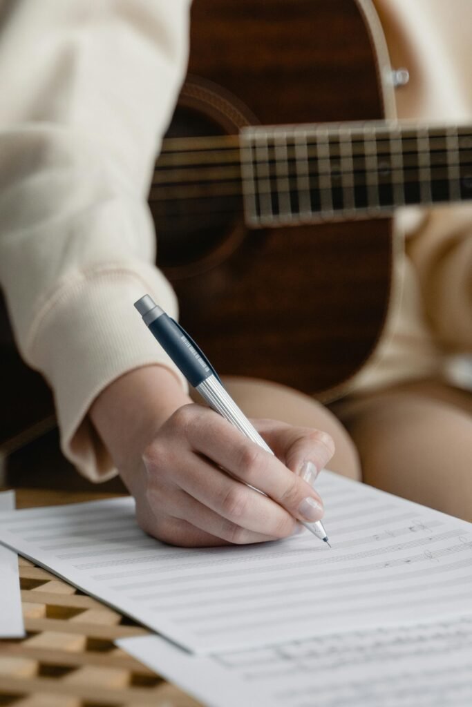 A hand is seen transcribing musical notes in this example of music careers.