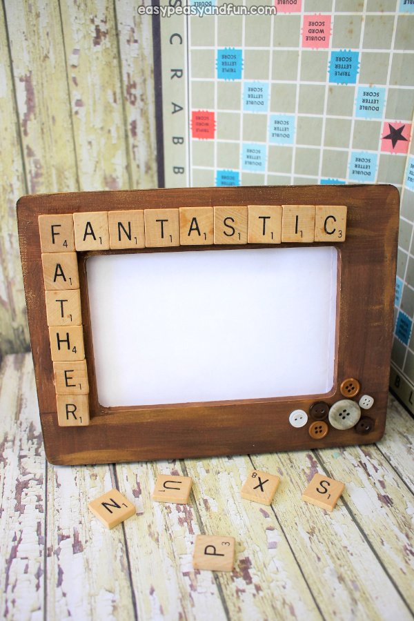 A wooden picture frame decorated with words made from Scrabble tiles