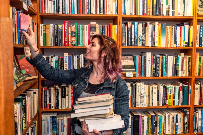 A woman putting books on the shelves of an independent bookstore in San Francisco's Mission District.