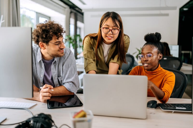 Three young colleagues discussing work at modern office