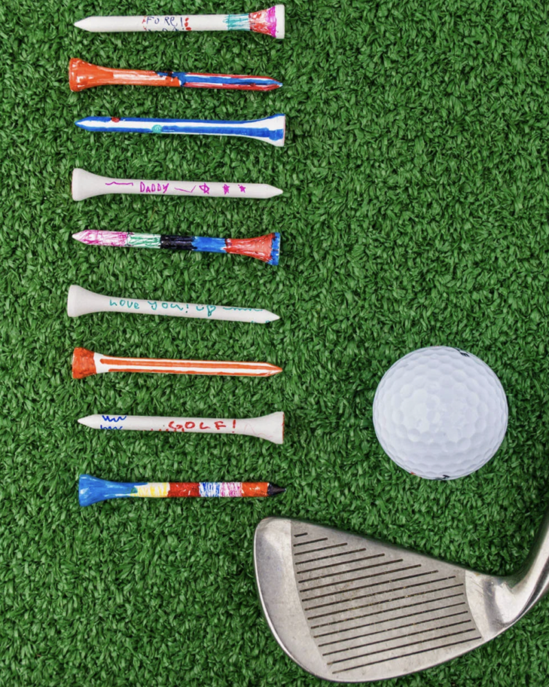 Several painted tees are shown. A golf club and ball are also shown 