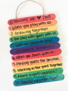 Several rainbow popsicle sticks are stacked together with sweet messages written on them in this example of Father's Day kids crafts.