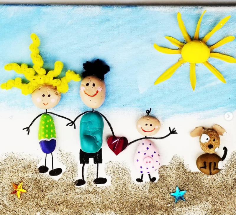 A mom, Dad, a child, and a dog are made from painted rocks as an example of Father's Day crafts for kids.