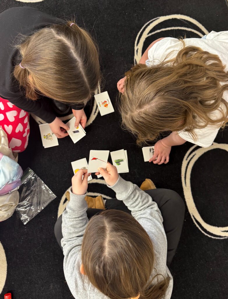 image of the tops of three children's heads playing with activity cards