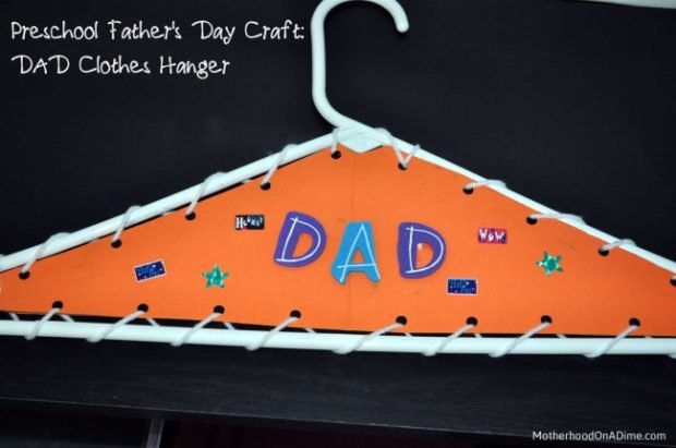 A clothes hanger that has been decorated and says Dad on it.