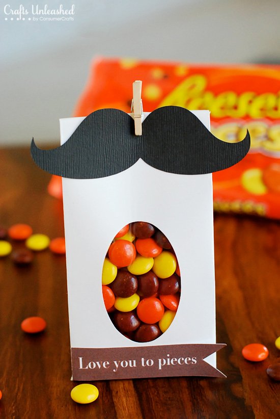 A white bag is filled with candy and has a black moustache on the top.