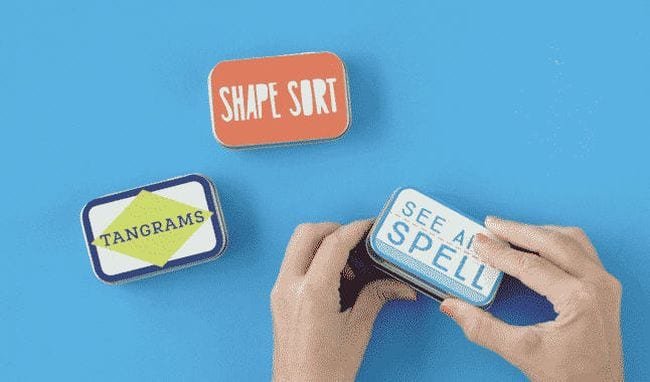 Metal tins are labelled and filled with mini games for kids as an example of inexpensive gift ideas for students