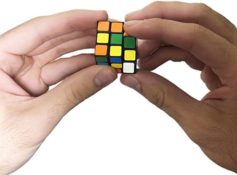 A child's hands hold a mini rubik's cube