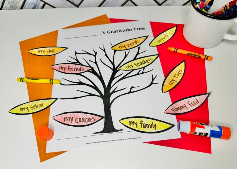 Gratitude tree project on table with crayons and glue stick.