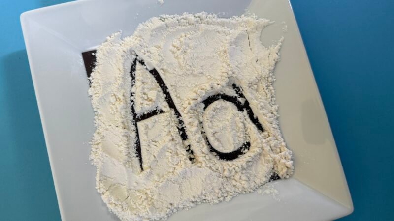 letters traced in flour on table