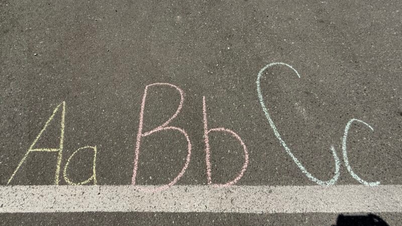 Letters written on sidewalk with colorful chalk