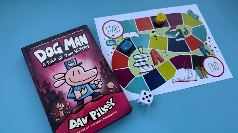 Colorful board game next to book