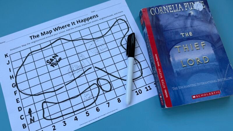 Paper with map drawn on it next to book