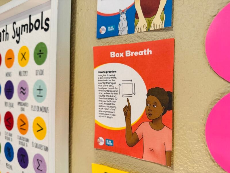 social-emotional learning activities breathing exercises posters in classroom and teacher holding up one poster