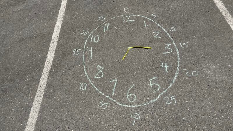 Chalk drawing of clock on sidewalk