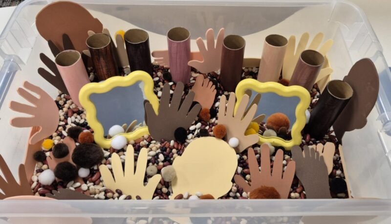 Inclusive Classroom Sensory Bin Sensory bin with foam hands and faces in a variety of skin tones, with mirrors as well