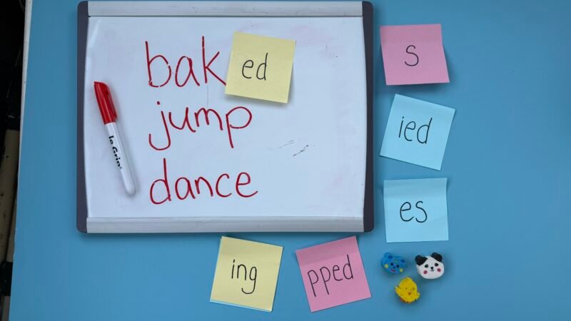 Construction paper with sticky notes and words baked, jump, dance on it