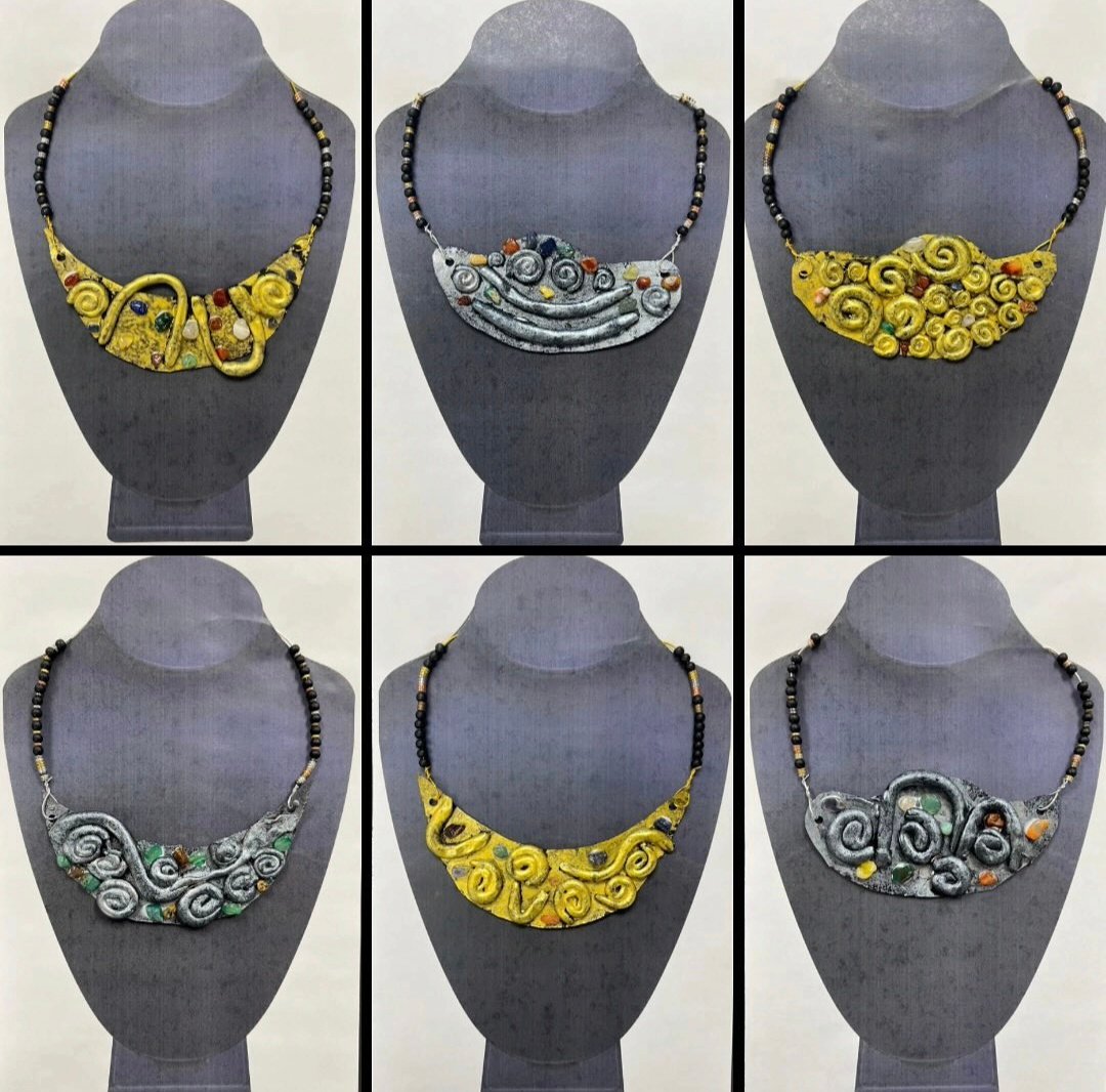 Clay necklaces displayed on jewelry stands