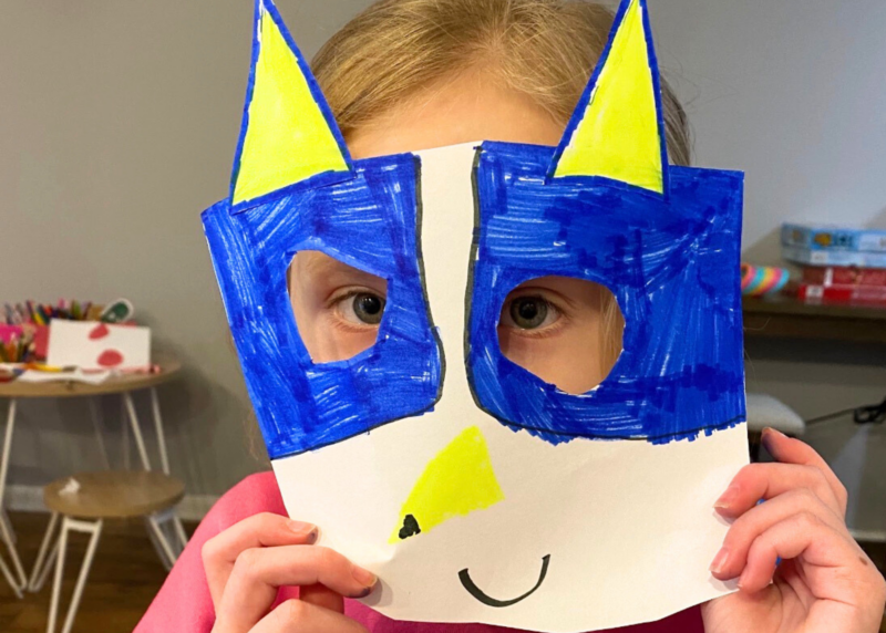 a student wearing a paper mask they created as a form of art therapy