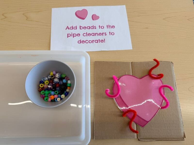 a pink heart paper with beads