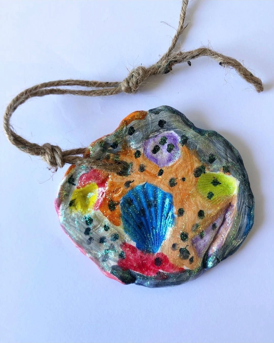 Clay ornament made by pressing shells and painting the indentations