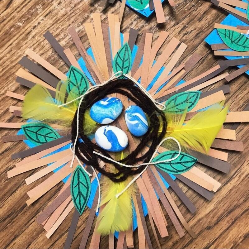 Birds nest made from paper scraps, yarn, and painted rocks