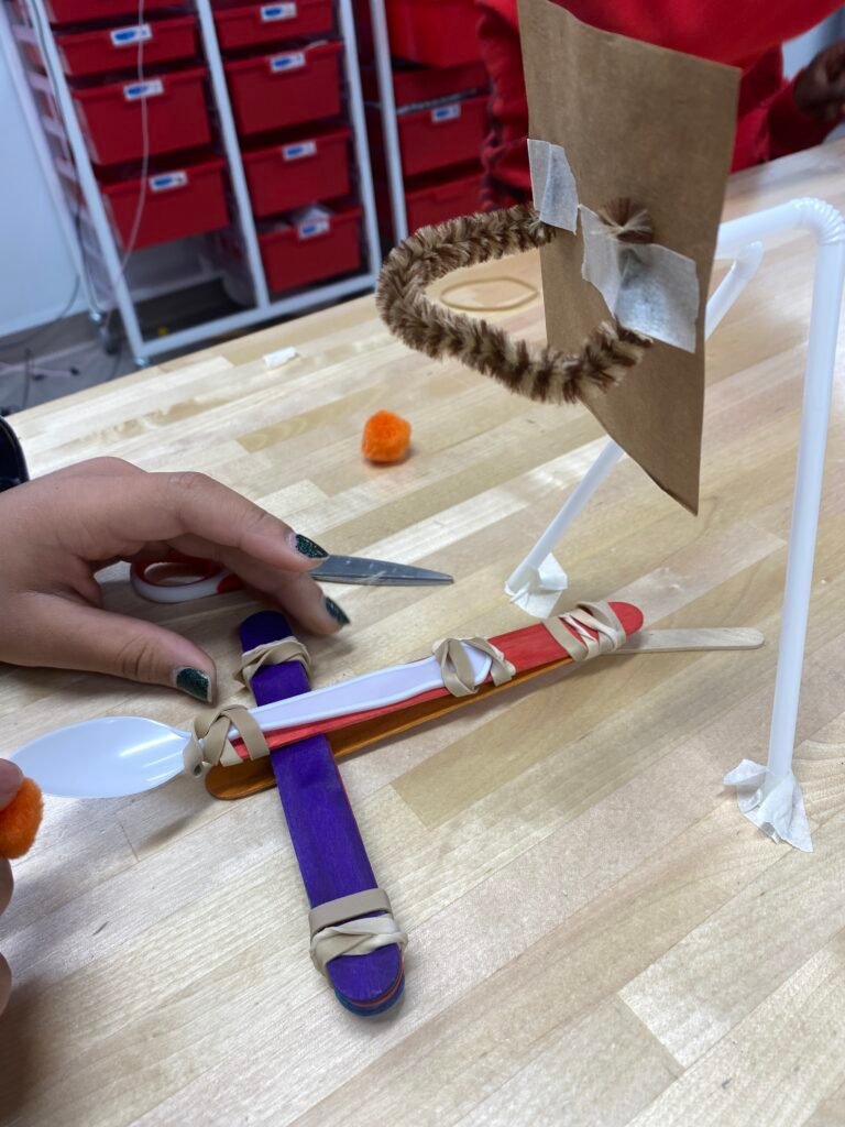 Kindergarten Science Experiments an image of a kindergarten science experiment that involves building a catapult