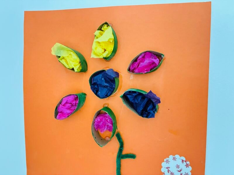 a summer craft for kids that involves creating a flower with a cardboard roll and tissue paper