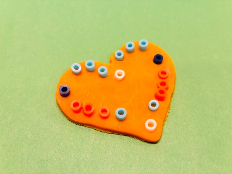Fine Motor Activities an image of a fine motor activity that involves students placing small beads into playdough to create a mosaic