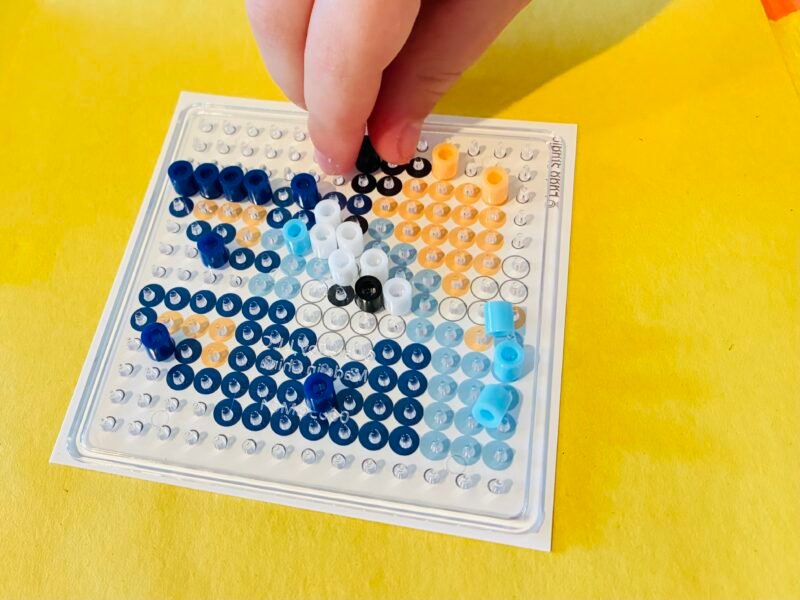 Fine Motor Activities an image of a fine motor activity that involves students making perler bead creations