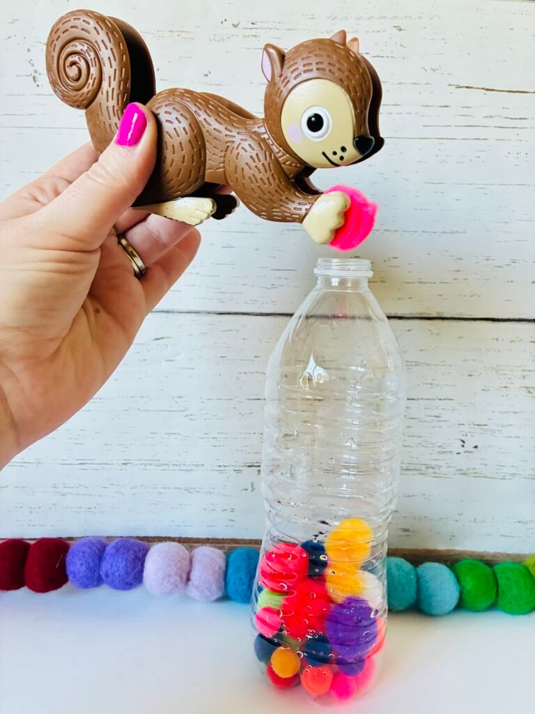 Fine Motor Activities an image of a fine motor activity that has students use toy tweezers and put pom-poms into a water bottle